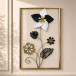 Metal wall art with star flower and monstera leaves in a gold rectangular frame