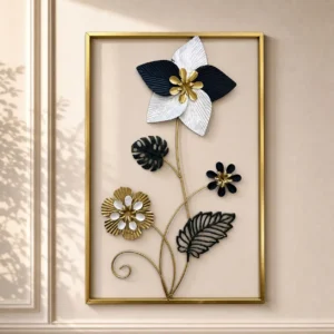 Metal wall art with star flower and monstera leaves in a gold rectangular frame