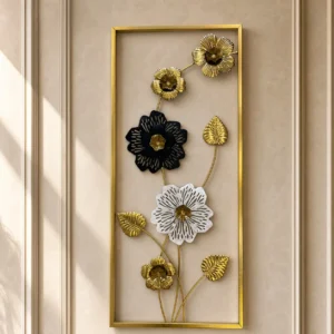 Tall metal wall art with gold black and white cutout flowers in a gold frame